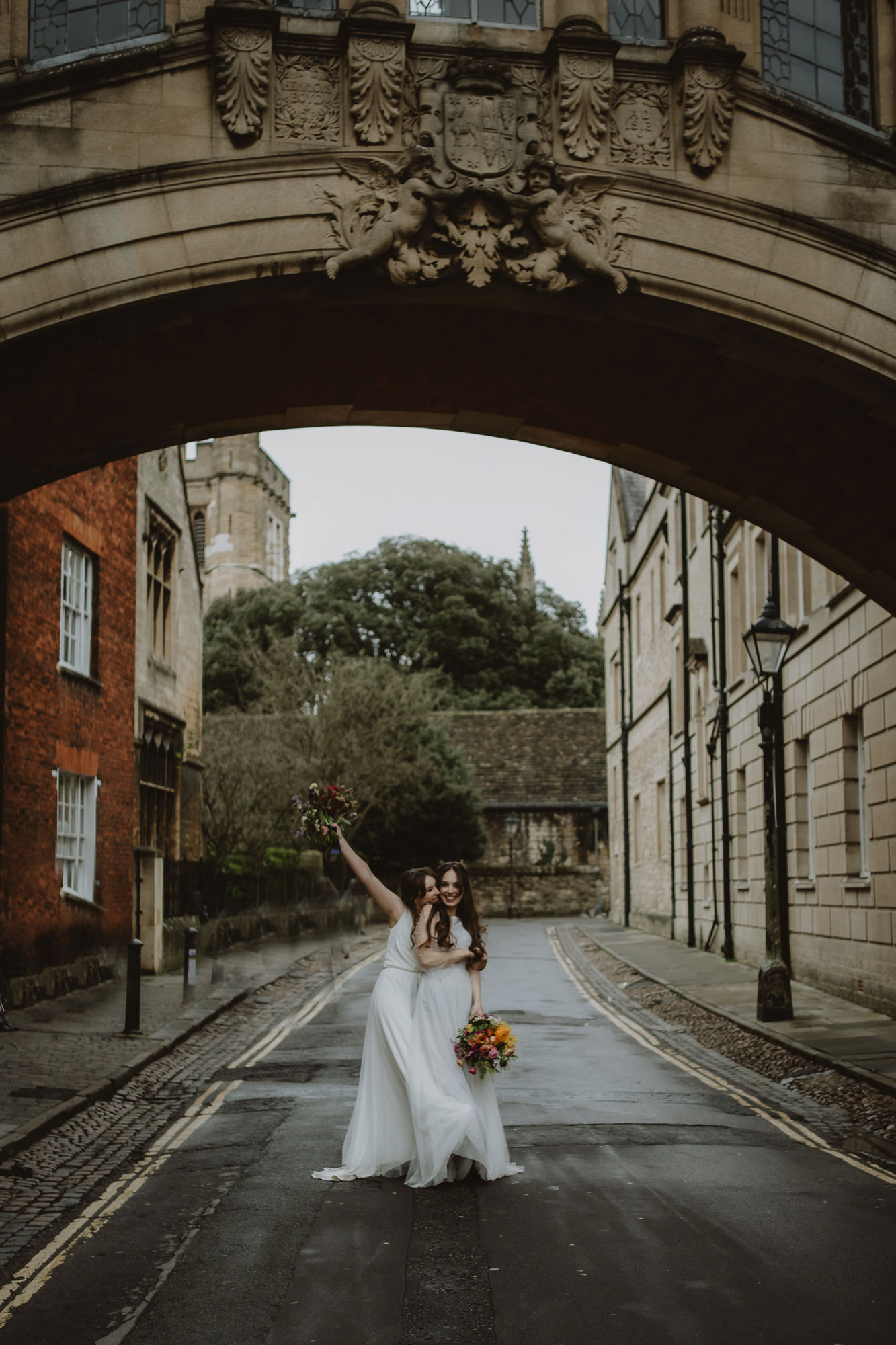 Two Brides dance under the bridge of sighs in Oxford city centre after their wedding