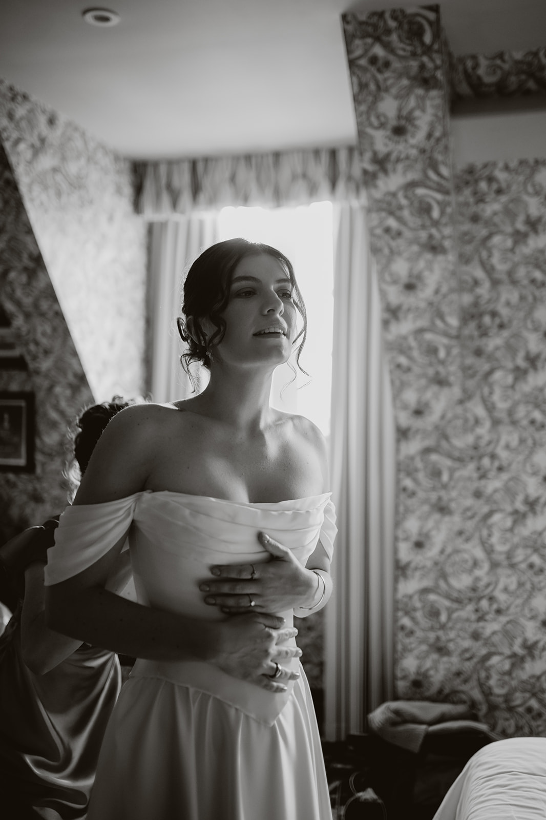 Black and white photos of a bride putting on her wedding dress